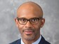 Portrait of Rayvon Fouché against a gray background.